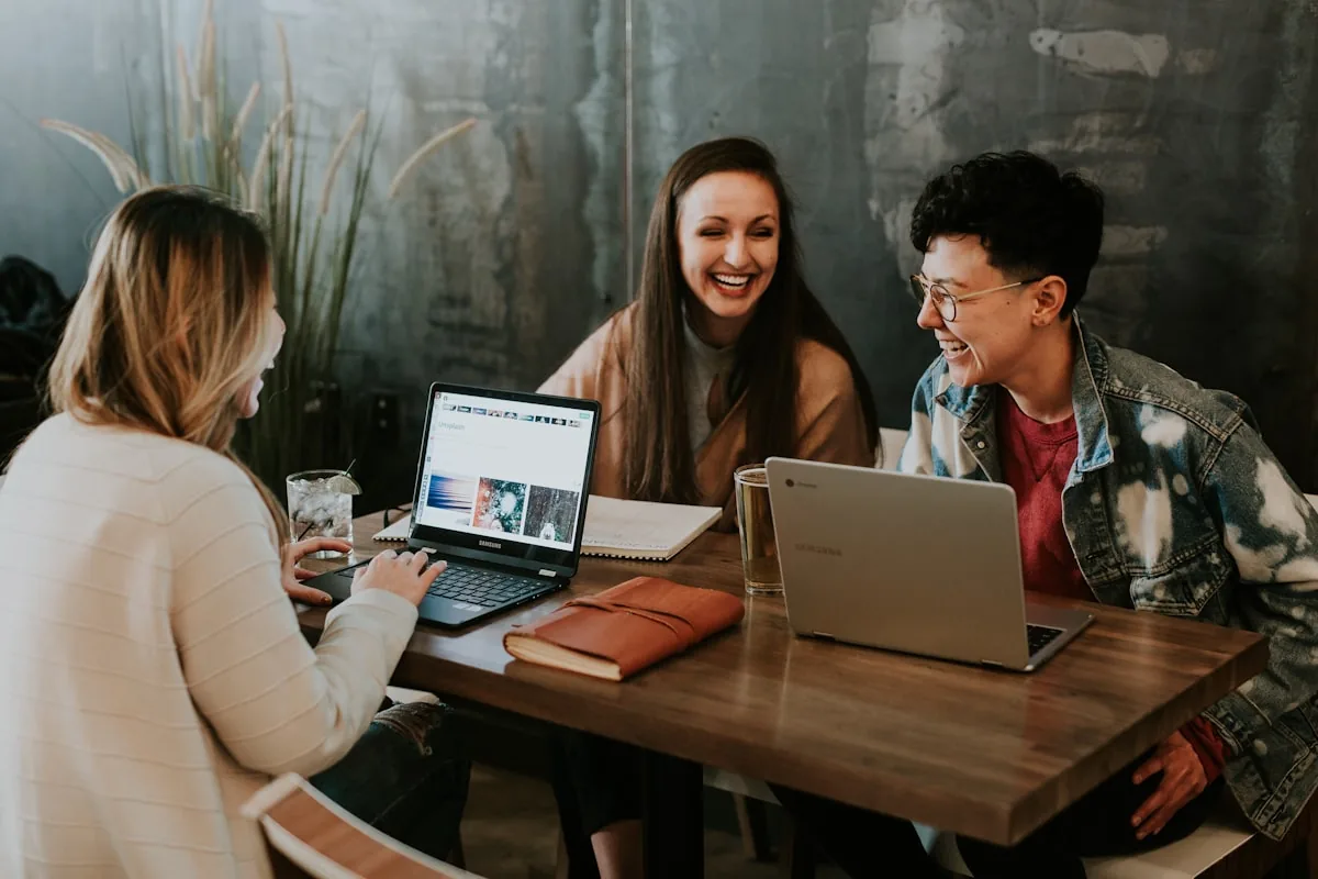Three people going through finances together at a kitchen table